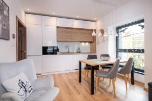 a kitchen and dining room with a table and chairs at TATRYSTAY Armeria Apartments in Štrbské Pleso