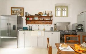 eine Küche mit weißen Schränken und einem Kühlschrank aus Edelstahl in der Unterkunft The Stone House in Zaton