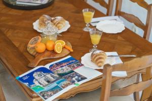 einen Tisch mit Brot und Orangen und Gläsern Orangensaft in der Unterkunft The Stone House in Zaton