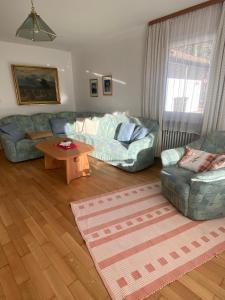 a living room with a couch and a table at Ferienhaus Endrös - Chiemgau Karte in Inzell