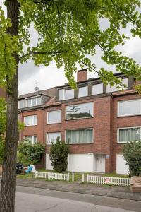 a brick building with a tree in front of it at - Cozy apartment in the heart of Duisburg with New York Design & Betten & Sofa - 5 Mins Central Station Hbf - Big TV & WiFi -· in Duisburg