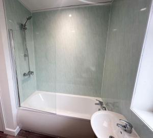 a bathroom with a shower and a sink and a tub at High Market Place by Blue Skies Stays in Ashington