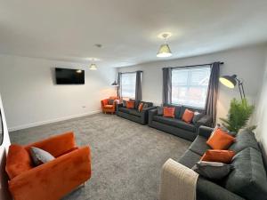 a living room with couches and a flat screen tv at High Market Place by Blue Skies Stays in Ashington
