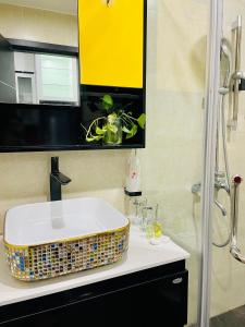 y baño con lavabo y ducha. en Vinhomes Green Bay G30332, en Hanói