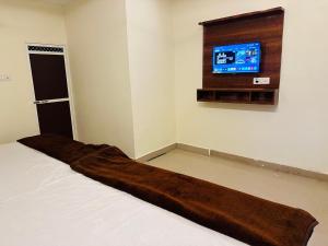1 dormitorio con 1 cama con manta marrón en Tanodiya Palace, en Ujjain
