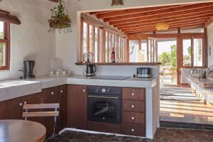 a kitchen with a stove top oven in a room at Casa Los Llanos in Playa de Santiago