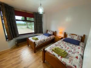a bedroom with two beds and a window at Bungalow in Badsey, north of the Cotswolds in Badsey