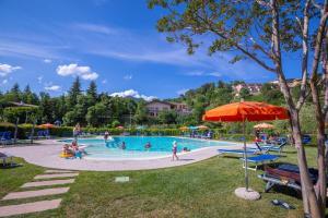 a group of people in a pool at a resort at Residence Bellevue Country Style - Happy Rentals in Tremosine Sul Garda