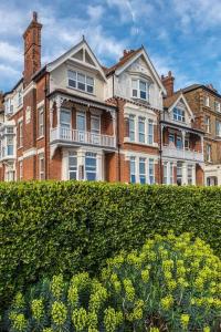 a large house with a hedge in front of it at Bay View - Private parking, beach views, central location in Kent