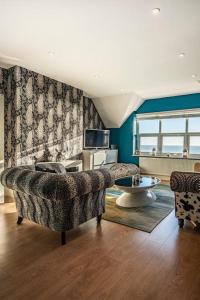a living room with a couch and a table at Bay View - Private parking, beach views, central location in Kent
