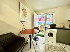 a kitchen with a table and a washing machine at Bethnal Green Rooms R3 in London