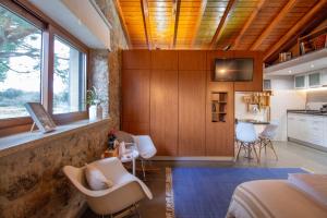a bedroom with a bed and a kitchen with a window at Casinhas da Póvoa- Turismo Natureza in Castelo de Vide