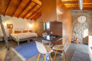 カステロ・デ・ヴィデにあるCasinhas da Póvoa- Turismo Naturezaのベッドルーム1室(ベッド1台、デスク、椅子付)