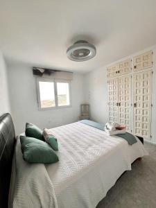 een slaapkamer met een groot wit bed met groene kussens bij Chalet Hungría Chalet con piscina privada in Peñíscola