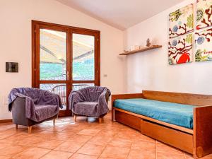 1 Schlafzimmer mit einem Bett, 2 Stühlen und einem Fenster in der Unterkunft Villetta Gaia in Conca Verde