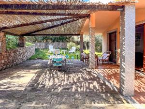 eine Terrasse mit einem Tisch und Stühlen unter einer hölzernen Pergola in der Unterkunft Villetta Gaia in Conca Verde