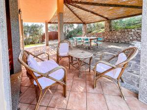 eine Terrasse mit Stühlen, Tischen und einem Tisch in der Unterkunft Villetta Gaia in Conca Verde
