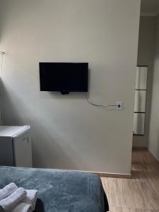 a bedroom with a flat screen tv on the wall at Pausado por tempo indeterminado in Itapira