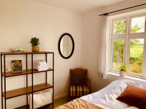 a bedroom with a bed and a mirror and a window at Fantastic farm holiday in Ebeltoft