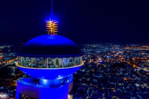 スライマーニーヤにあるGrand Millennium Sulaimaniの夜の街を背景にした青い管制塔