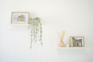 uma parede branca com duas imagens e uma planta sobre ela em Duplex OverTheTejo, 5 min Belém Tower em Lisboa