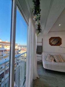um quarto com uma cama e uma varanda com uma janela em Duplex OverTheTejo, 5 min Belém Tower em Lisboa