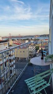 a balcony with a table and a view of a city at Duplex OverTheTejo, 5 min Belém Tower in Lisbon