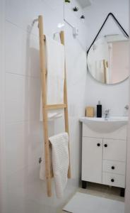 uma casa de banho com uma escada ao lado de um lavatório e um espelho em Duplex OverTheTejo, 5 min Belém Tower em Lisboa