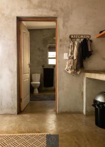 a hallway with a bathroom with a toilet and a door at Guest Room at Joubert in Piet Retief