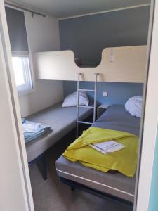 Cette chambre comprend 2 lits superposés et une fenêtre. dans l'établissement Mobil Home les pieds dans l'eau, à Sarzeau