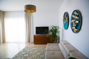 a living room with a couch and a tv at Panoramic Ocean view in Puerto de Santiago