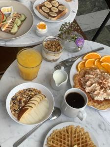 a table topped with plates of breakfast foods and coffee at 2Home Hotel Apartments in Solna