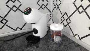 uma máquina de café e um recipiente na casa de banho em Апартаменти - Історія з вікна em Kamianets-Podilskyi