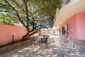 a patio with chairs and a tree next to a building at Appartamento Levante a 300m dalla spiaggia in Golfo Aranci