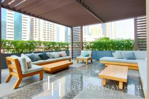 a patio with couches and chairs on a balcony at LUX The Elegant DIFC Suite in Dubai