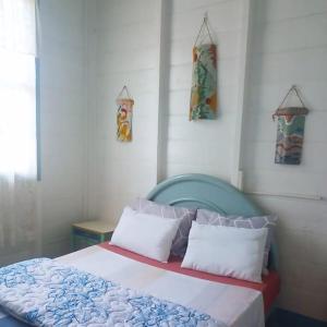 a bedroom with a bed with a blue head board at Pousada Maranata B&B in Paranapiacaba