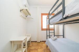 een slaapkamer met een stapelbed en een bureau bij Murta 26 in Sa Coma
