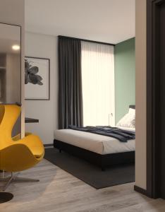 1 dormitorio con 1 cama y 1 silla amarilla en Residence Il Melograno, en Sirmione