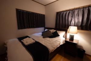 a small bedroom with a bed with a lamp at Sui HOUSE 北赤羽 in Tokyo