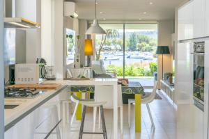 a kitchen with white cabinets and a counter with stools at Tarida in Alcudia
