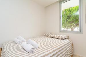 a bedroom with a bed with pillows and a window at Tarida in Alcudia
