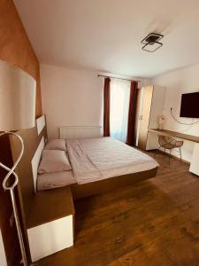 a small bedroom with a bed and a desk at Green Garden in Suceava