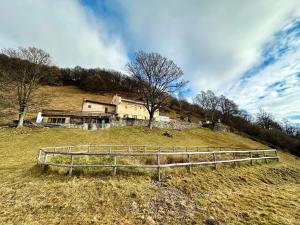 uma casa no topo de uma colina com uma cerca em Alpe di Caviano em Castel San Pietro