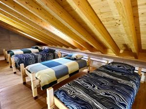 a row of beds in a room with wooden ceilings at Alpe di Caviano in Castel San Pietro