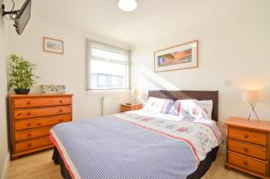 um quarto com uma cama, uma cómoda e uma janela em 35 Sandown Bay Holiday Park em Sandown