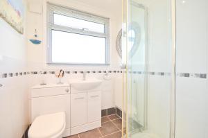 uma casa de banho com um chuveiro, um WC e um lavatório. em 35 Sandown Bay Holiday Park em Sandown