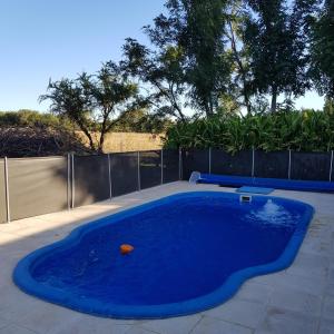 una piscina azul en un patio con una valla en Finca La Bona Font Casa Rural en Cortaderas