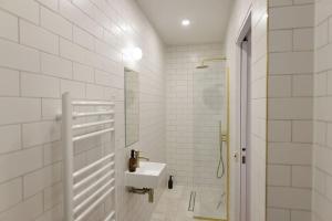 a white bathroom with a sink and a shower at The Lookout - Stylish penthouse with sea views in Kent