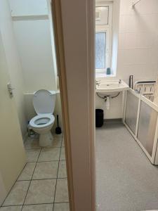 a bathroom with a toilet and a sink at Cosy 1 bedroom flat… in London