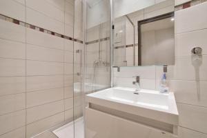 une salle de bain blanche avec un lavabo et un miroir dans l'établissement 12 Trachel - T2 lumineux au coeur de Nice, à Nice